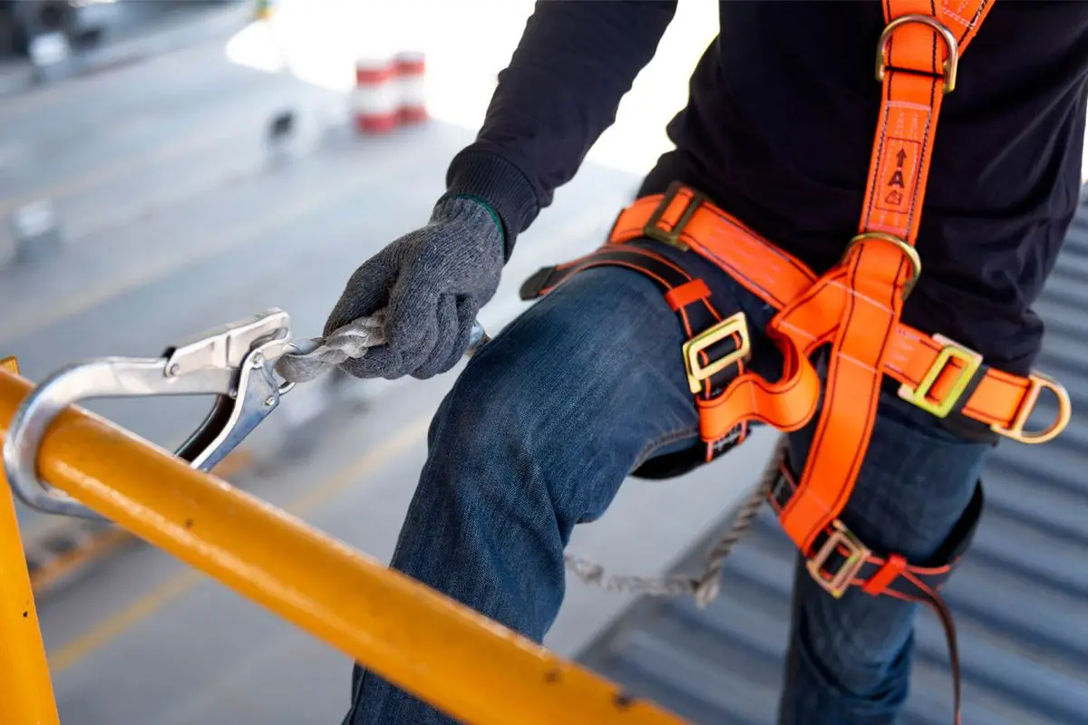 A worker clipping into fall-arrest harness equipment before working at height